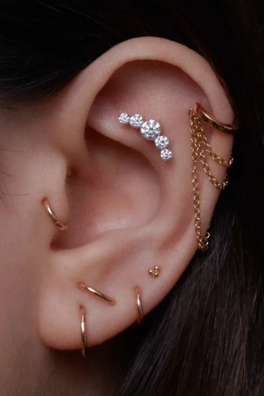 Piercing em curva com cinco diamantes 