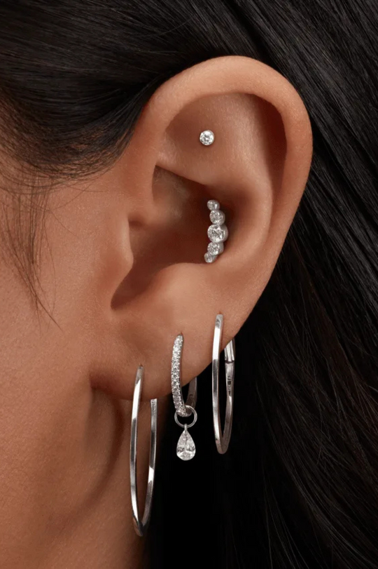 Piercing em curva com cinco diamantes 